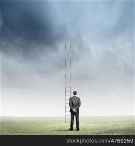 Ladder of success. Rear view of businessman standing near ladder going high in sky