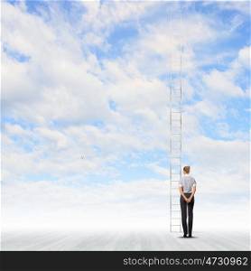 Ladder on top. Businesswoman standing with back near long ladder to sky