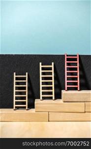 Ladders on the wall. Concept for success and growth. Stairs made of wooden blocks. Blue wall. 