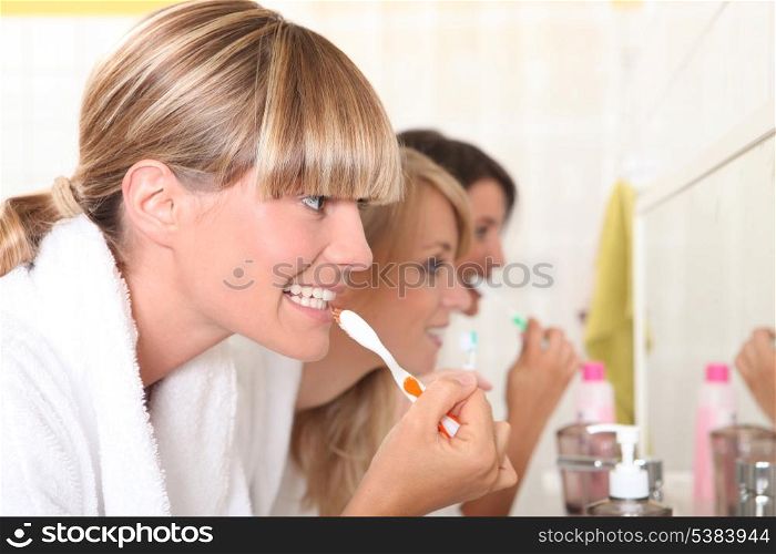 Ladies brushing their teeth
