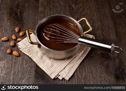 ladle with liquid chocolate. Dark background. . ladle with liquid chocolate