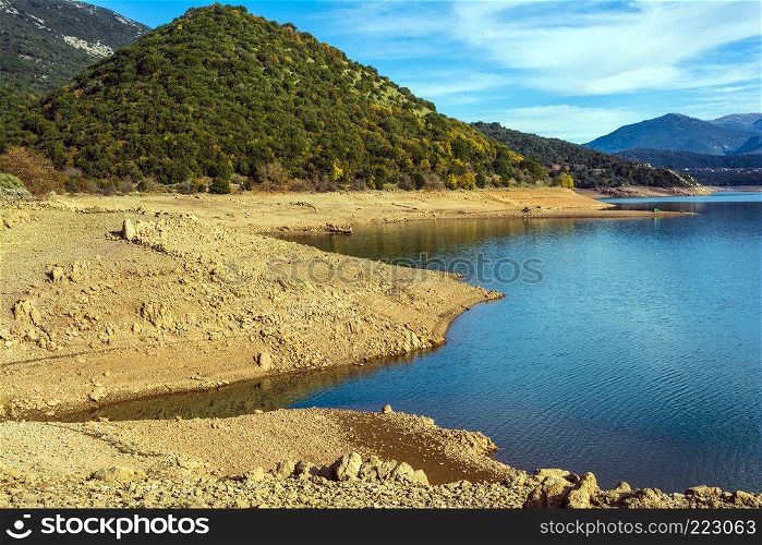 Ladonas artificial lake in Arcadia, Greece against a blue sky with clouds, and mountains as background. Ladonas artificial lake in Greece against a blue sky with clouds, and mountains as background