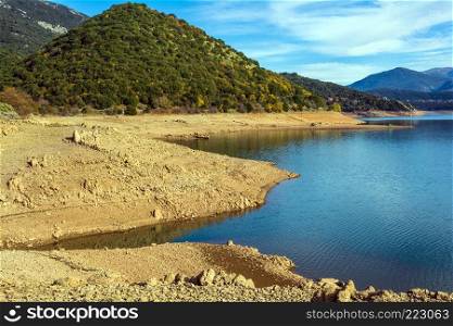 Ladonas artificial lake in Arcadia, Greece against a blue sky with clouds, and mountains as background. Ladonas artificial lake in Greece against a blue sky with clouds, and mountains as background