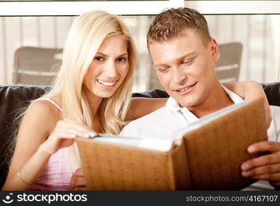 Lady and guy going through album and cherishing past days