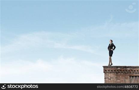 Lady boss. Confident pretty businesswoman standing on building top