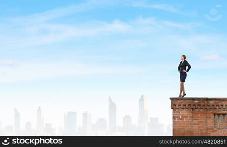 Lady boss. Confident pretty businesswoman standing on building top