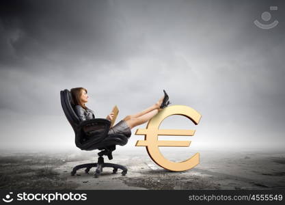 Lady boss. Young attractive businesswoman sitting in chair and reading book