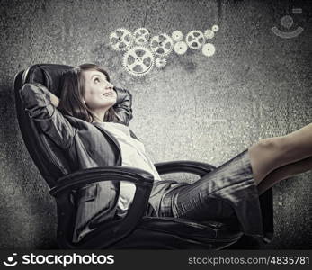 Lady boss. Young confident businesswoman sitting in chair with legs up