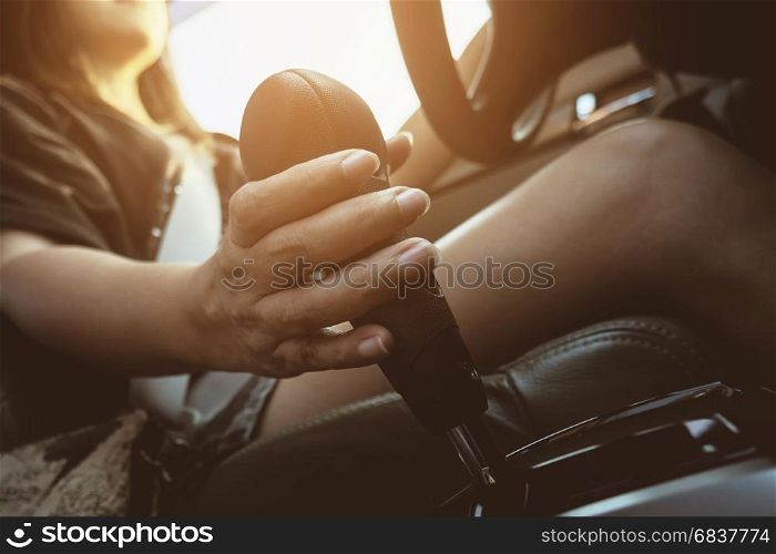 Lady driving car holding automatic gear shift transmission control