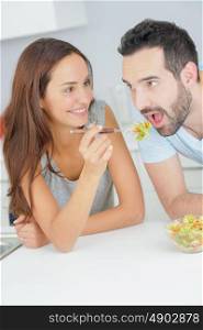 Lady feeding salad to man