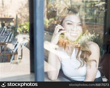 Lady happily using mobile phone in coffee shop