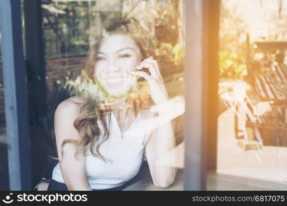 Lady happily using mobile phone in coffee shop