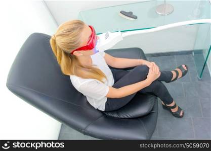 lady having dental treatment, wearing protective glasses