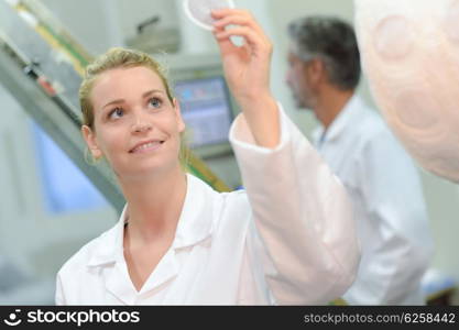 Lady holding round plastic disc up to the light