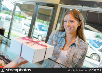 Lady in bakery being passed box