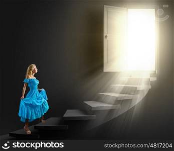 Lady in blue. Young woman in blue dress walking up the stairs