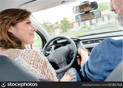 Lady in drivers seat of car, listening to man