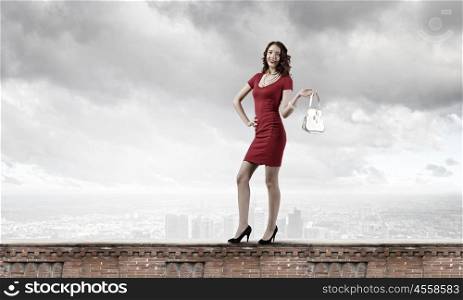 Lady in red. Young attractive woman in red dress with bag in hand