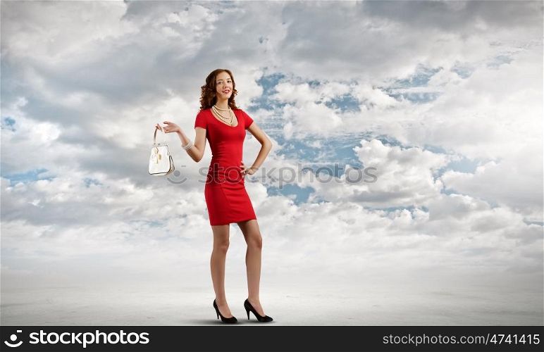 Lady in red. Young attractive woman in red dress with bag in hand