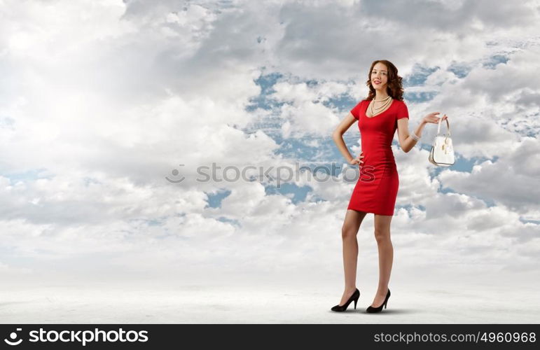 Lady in red. Young attractive woman in red dress with bag in hand