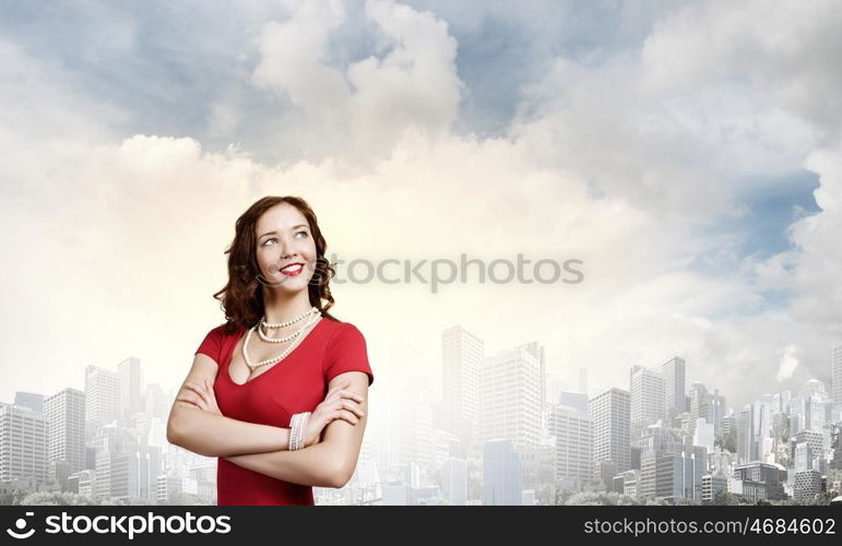 Lady in red. Young woman in red dress against city background