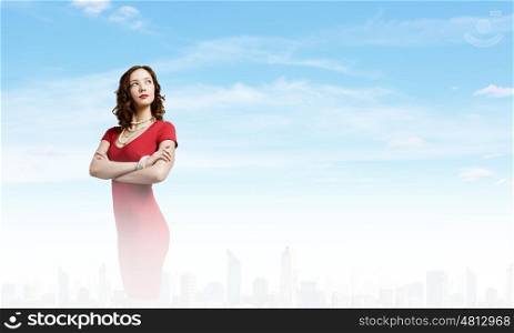 Lady in red. Young woman in red dress against city background