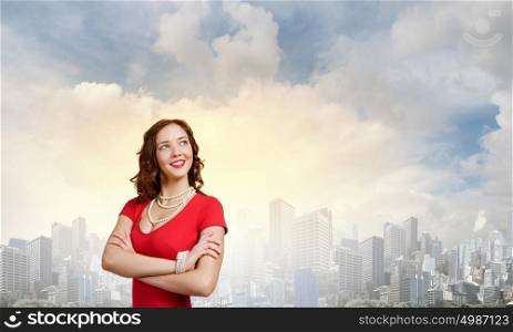 Lady in red. Young woman in red dress against city background
