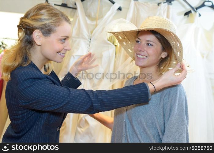 Lady in wedding shop being fitted with headwear