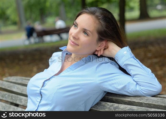 Lady leaning back on park bench