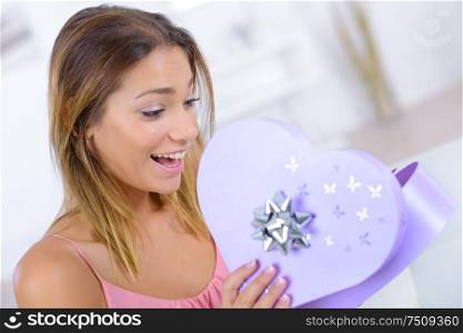 lady looking excitedly into heart shaped giftbox