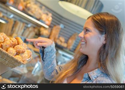 Lady pointing to little cakes in a bakery