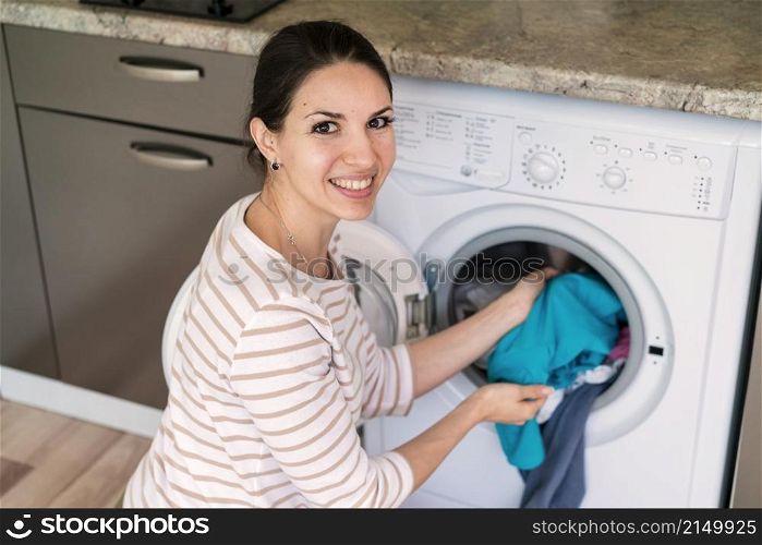 lady putting clothes washing machine