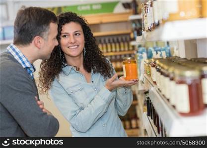 Lady showing jar of honey to customer