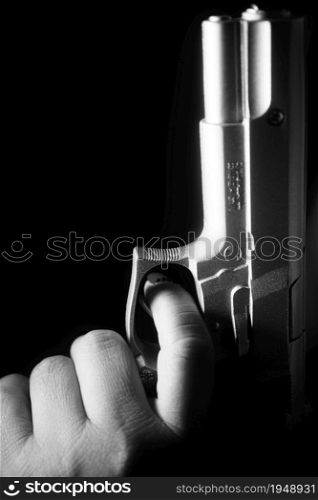 Lady spy detective with painted red nail varnish holding pistol gun at night