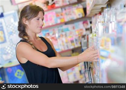 Lady tidying shelves in newsagents