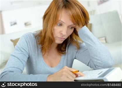 Lady using calculator, stressed