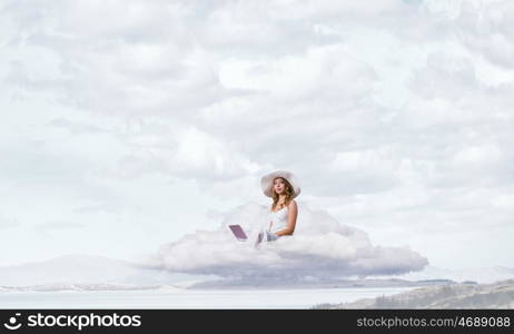 Lady using laptop. Young lady sitting on cloud with laptop on knees