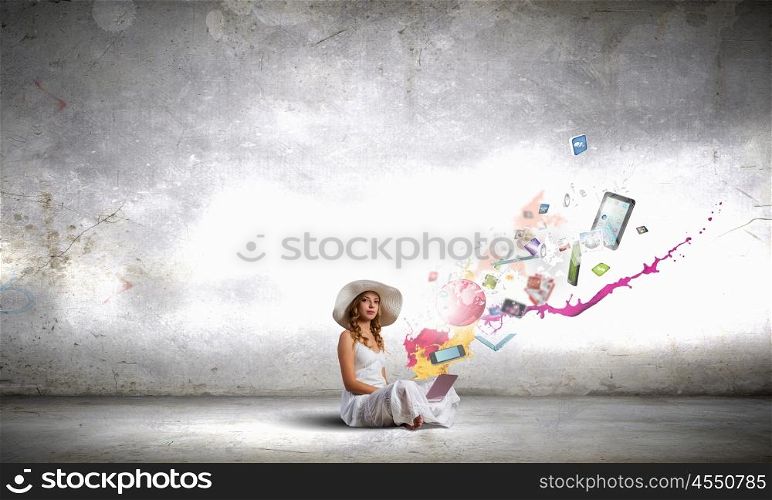 Lady using laptop. Young lady sitting on floor with laptop on knees