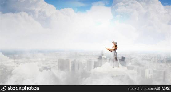 Lady using laptop. Young lady standing on cloud and using laptop