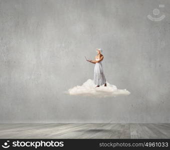 Lady using laptop. Young lady standing on cloud and using laptop