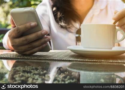 Lady using mobile white drinking coffee