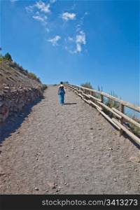 Lady walking for exercises during a sunny day on a mountain path