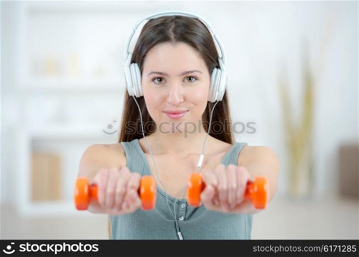 Lady with headphones and dumbbells