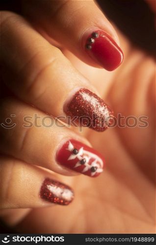 Lady with painted red nail varnish nails and manicure hands.