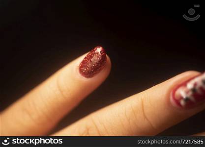 Lady with painted red nail varnish nails and manicure hands.