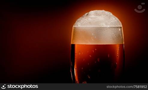 Lager beer settles in the glass with a white cap of foam