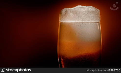 Lager beer settles in the glass with a white cap of foam