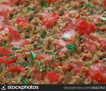 Lahmacun - round, thin piece of dough topped with minced meat and minced vegetables