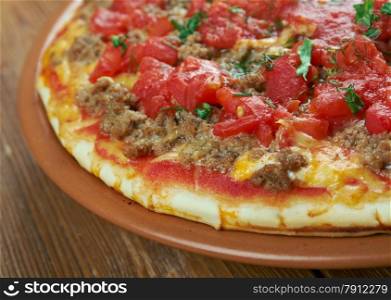 Lahmacun - round, thin piece of dough topped with minced meat and minced vegetables