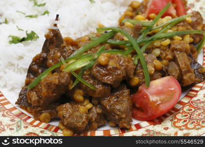 Lahore (Pakistan) style lamb and Chana dhal (split pea) curry, garnished with sliced chillies and chopped tomato, and served with white rice.